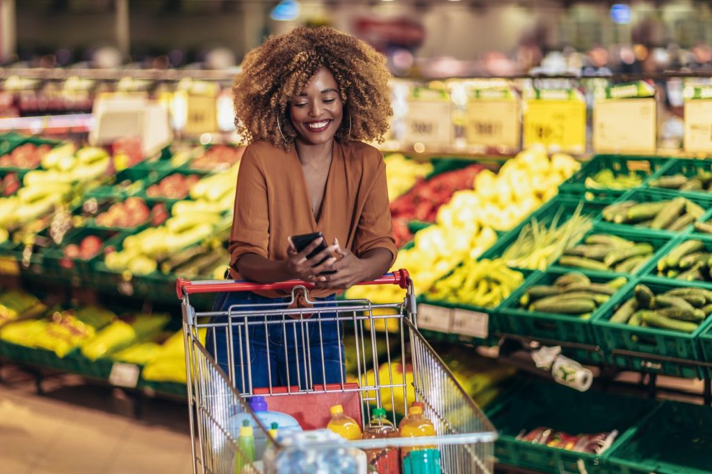 Woman shopping at the grocery store and looking at her phone
