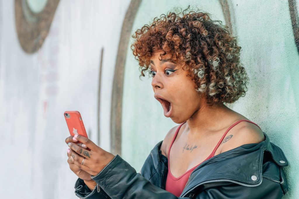 Shocked woman looking at her phone