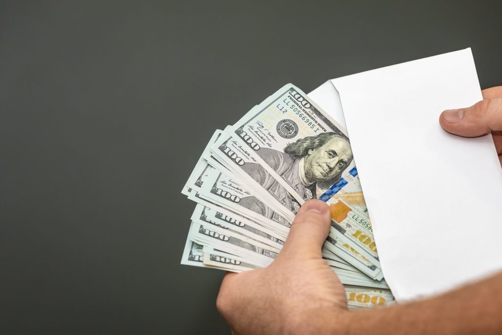 Hand pulling money from an envelope.