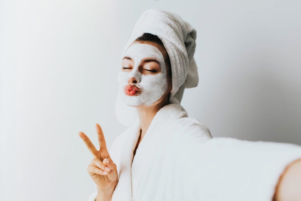 Woman in a robe and facial mask for DIY spa treatment