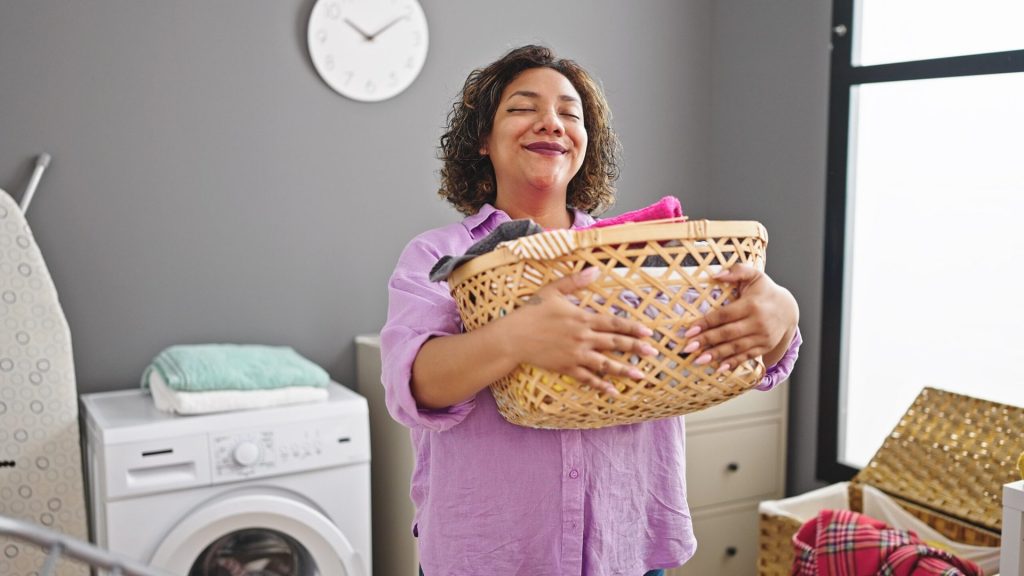Happy woman with a basket of clean laundry