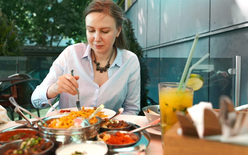 Woman eating Indian food.
