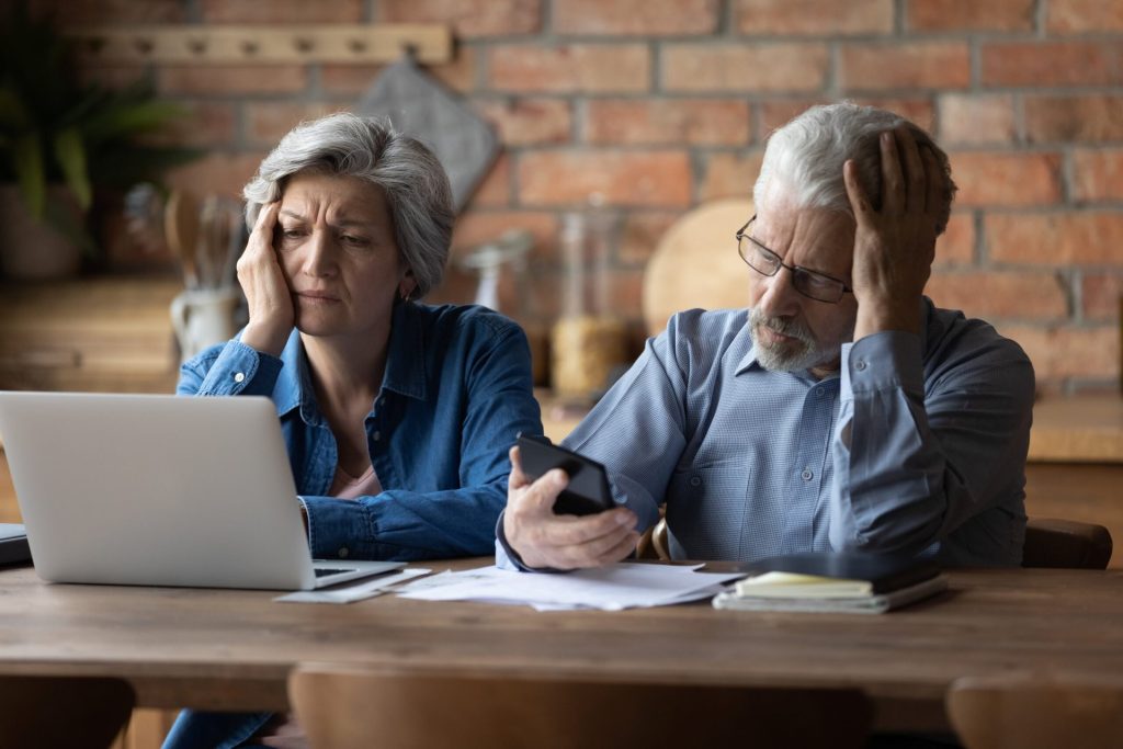 unhappy senior couple looking at bills