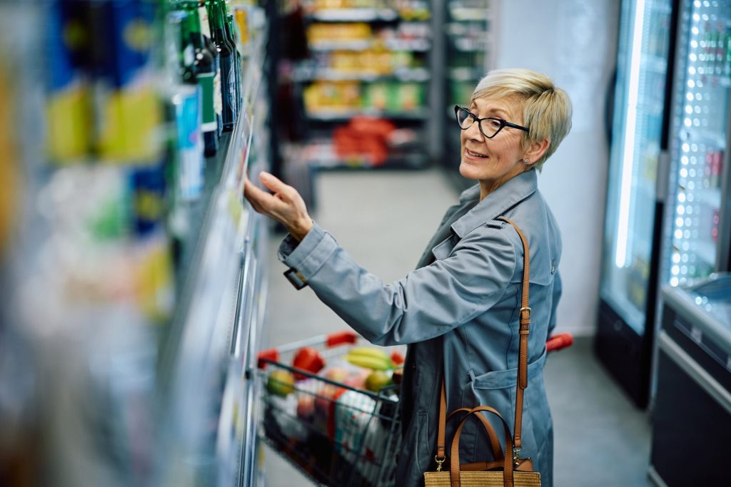 Happy senior woman shopping for groceries at a supermarket.