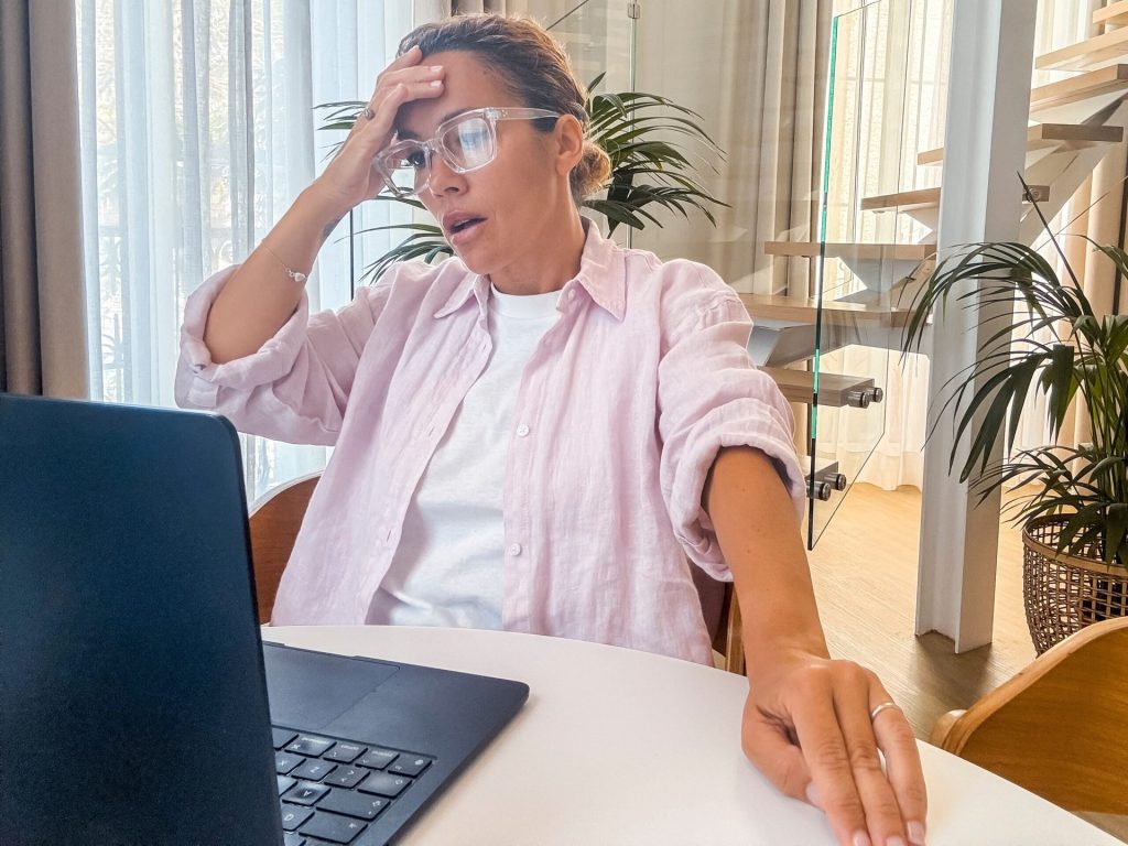 Upset woman looking at her laptop at home