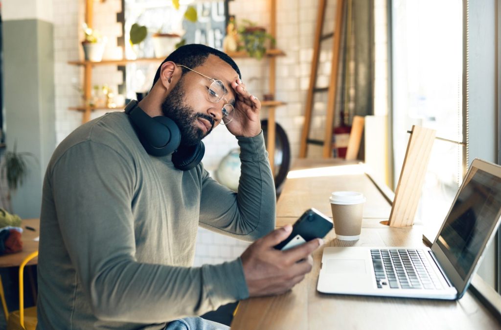How Wage Increases Compare to Inflation, According to Workers Man working remotely, stressed out. Holding phone.
