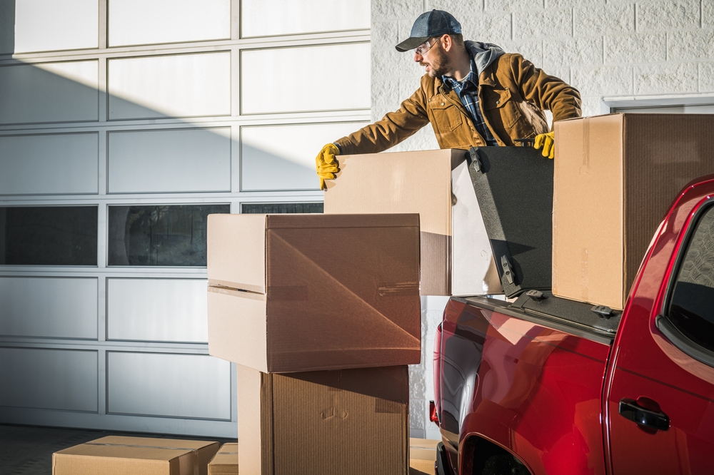 How to Make Quick Bucks with Pick-Up Trucks Man unloading a red pick up truck, indicative of making money with his pick up