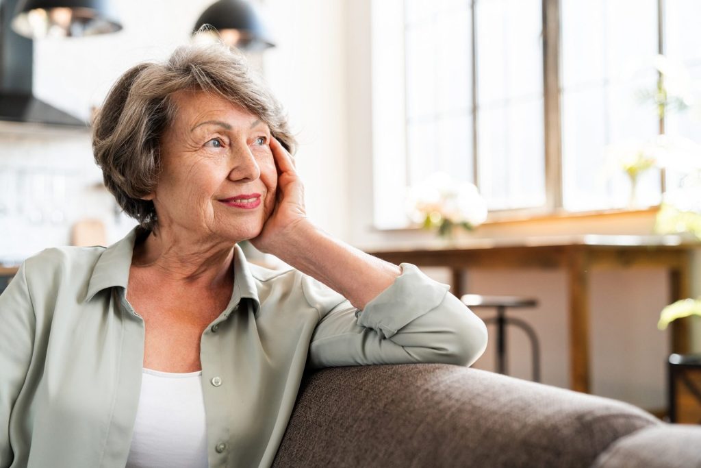 Happy senior woman at home on the couch