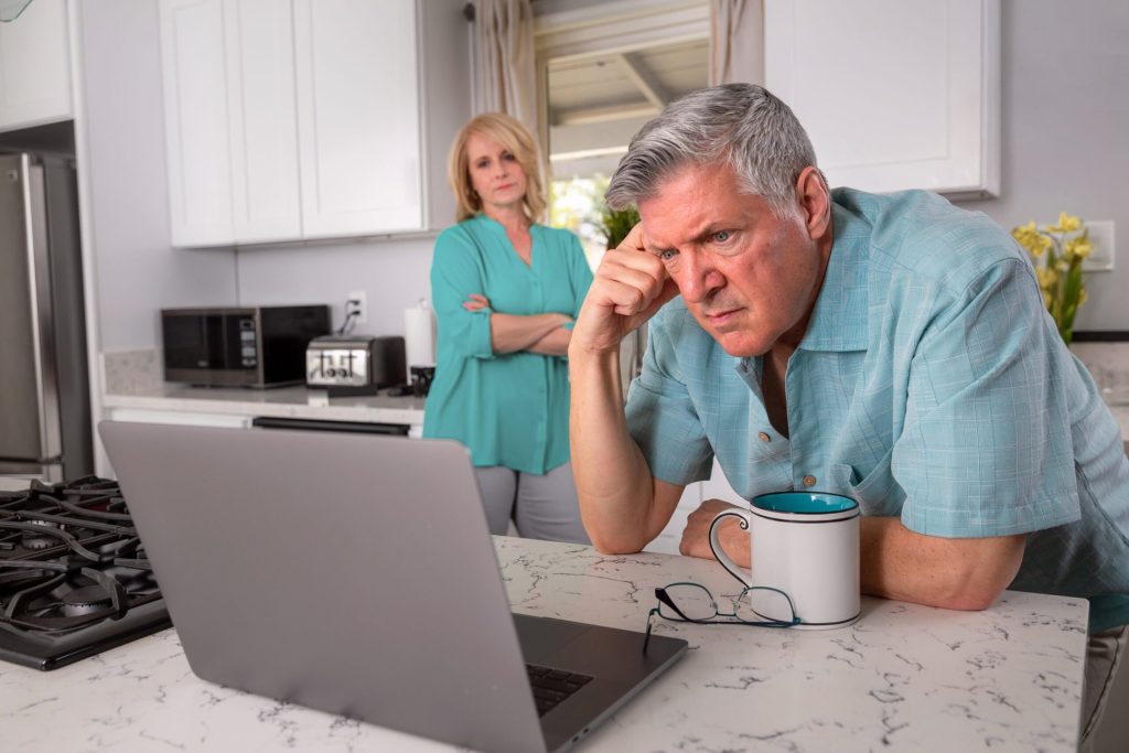 Worried senior couple looking at a laptop