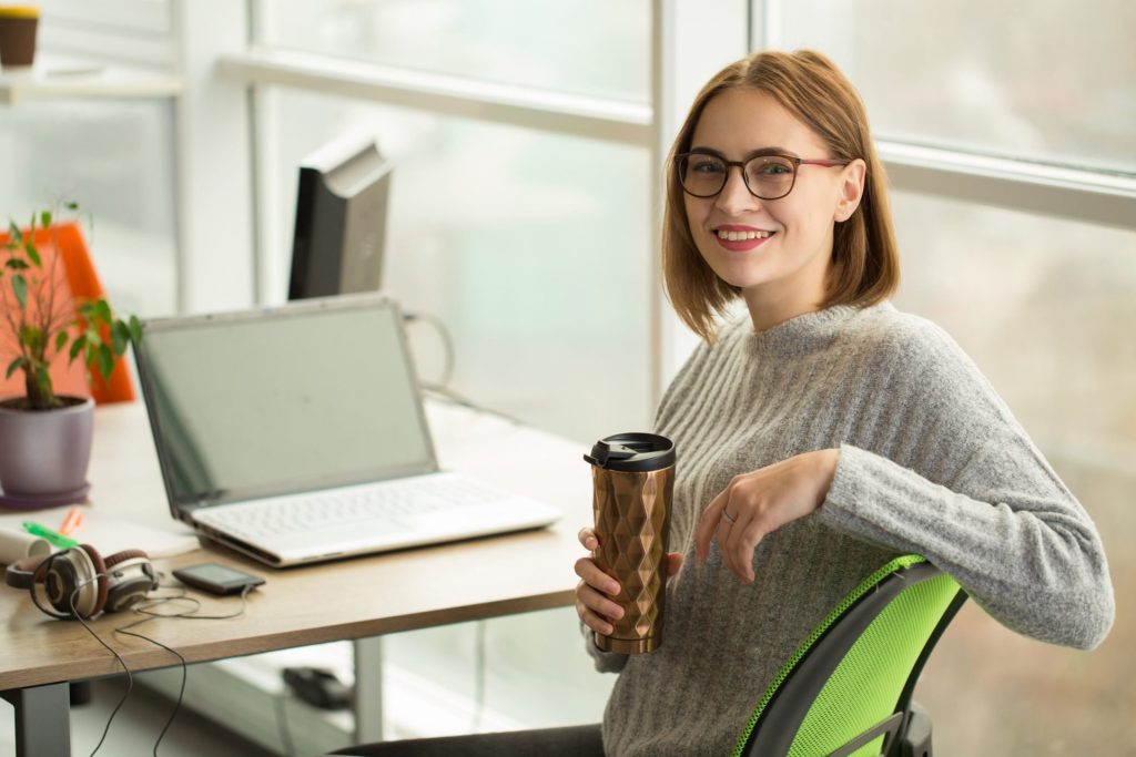 woman holding a reusable thermos